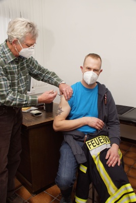 Ein Feuerwehrmann wird durch Dr. med. Heinz-Jörg Fresen geimpft